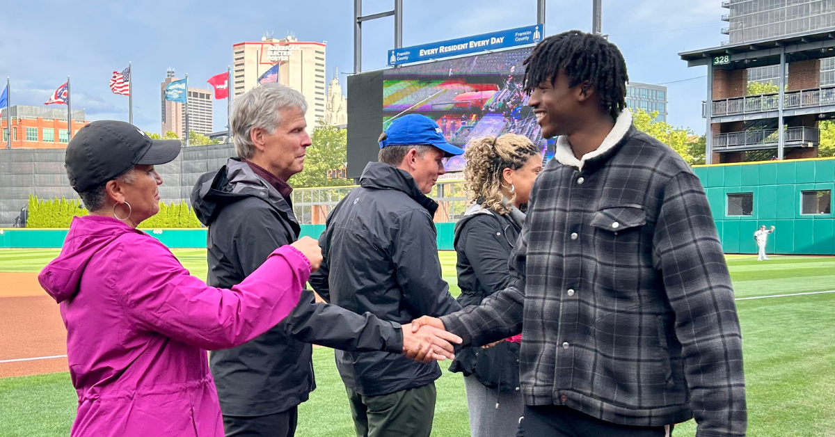Student shaking hands with adults